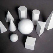 Geometric forms arranged in a group, featuring spheres, cubes, cones, pyramids, and cylinders in a classical study composition. Side View
