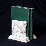 Sphinx-shaped ornate bookends with classical old world European detailing, supporting two upright hardcover books. Different Angle