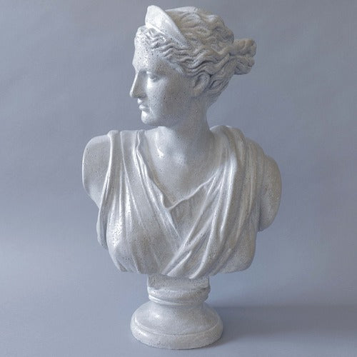 Classical Greek-style bust of a woman with draped garments and a headband, featuring detailed, ornate sculptural elements.