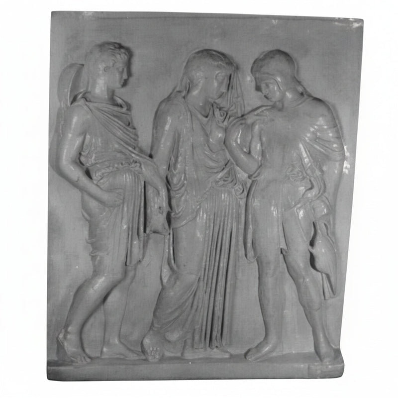 Classical Greek relief sculpture featuring three draped figures in flowing robes with detailed, ornate folds and ancient attire.
