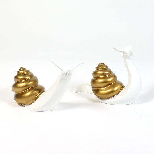 Pair of ornate snails with Baroque-inspired spiral shells and smooth, stylized bodies in a classical old world European design.