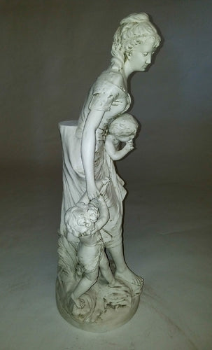 Classical European statue of a woman with two children, featuring ornate, old world detailing and Renaissance-inspired drapery. Side Angle