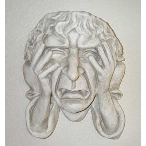 Grotesque old world European wall sculpture of a distressed face with hands pressed to cheeks, featuring dramatic, ornate details.
