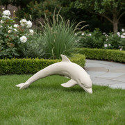 Dolphin sculpture with smooth, classical lines and subtle old world European influence in a graceful, arched swimming pose. Side Angle