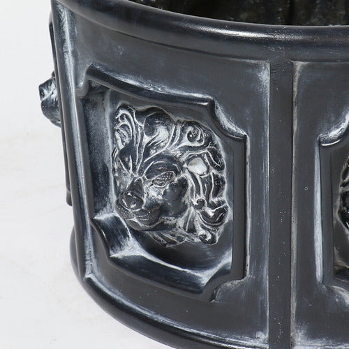 Ornate round planter with classical lion head reliefs in an old world European Baroque style, featuring detailed sculptural panels. Side Angle