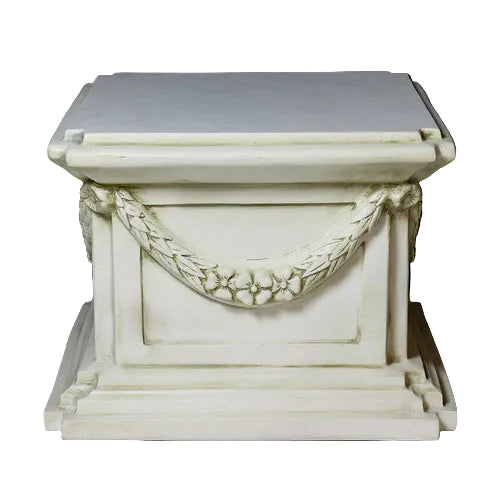 Classical pedestal with ornate garland detailing, square base, and stepped edges in an old world European architectural style. Side View