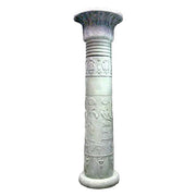 Ornate classical column with carved Egyptian motifs, fluted shaft, and lotus capital in an old world architectural style.