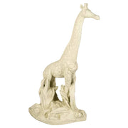 Giraffe statue with ornate detailing and classical old world European style, standing on a textured base with sculpted foliage.