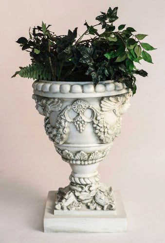 Ornate Baroque urn planter with cherub reliefs, classical garlands, and intricate old world European detailing on a square pedestal base Different Angle