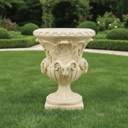 Ornate classical urn with Baroque detailing, featuring sculpted ram heads and intricate leaf motifs in old world European style. Side Angle