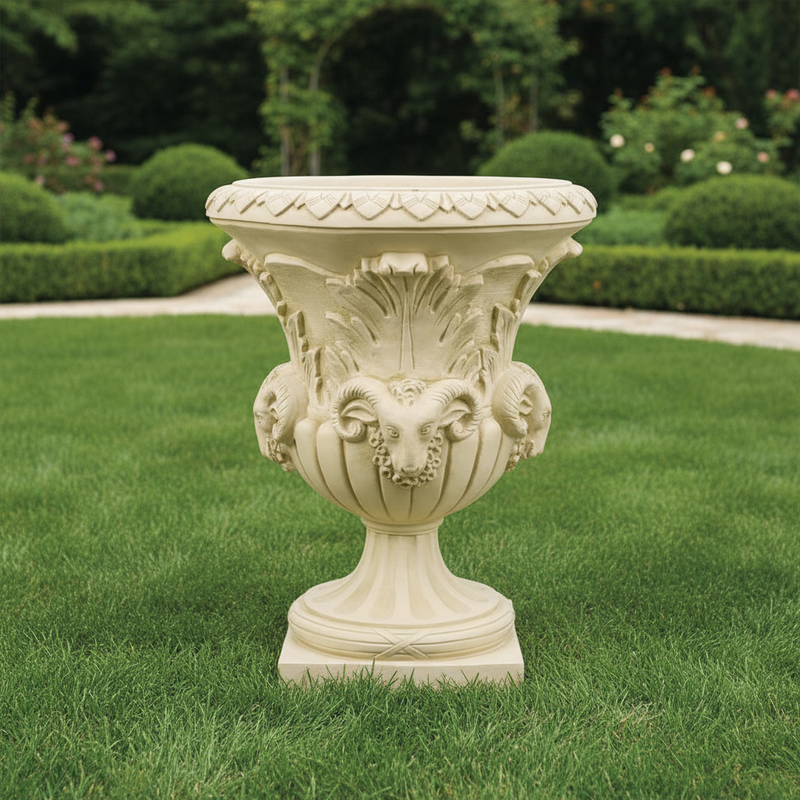 Ornate classical urn with Baroque detailing, featuring sculpted ram heads and intricate leaf motifs in old world European style. Side Angle