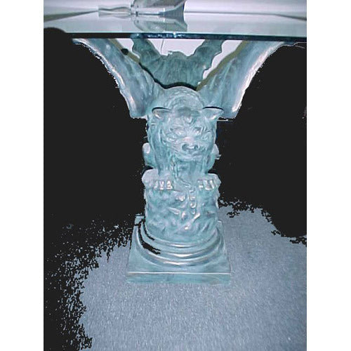 Gothic-style table base featuring an ornate gargoyle sculpture with classical detailing supporting a glass tabletop.