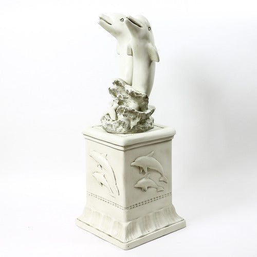 Dolphin sculpture with two dolphins leaping above ornate pedestal featuring classical reliefs in old world European style. Side View