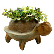 Turtle-shaped planter with ornate, old world European detailing and Renaissance-inspired sculptural features, filled with lush greenery.