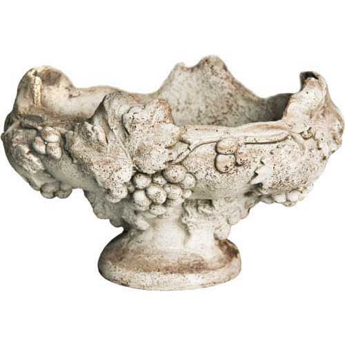 Ornate old world European pedestal bowl with classical grape and leaf relief, featuring a weathered, antique finish and scalloped rim.