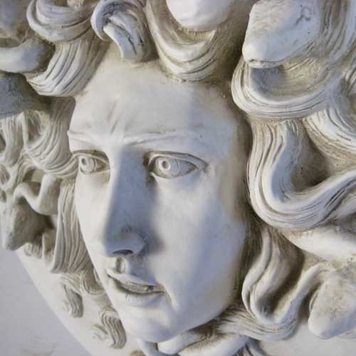 Medusa head relief with intricate serpentine hair, classical Greek style, ornate detailing, and dramatic facial expression. Other Angle