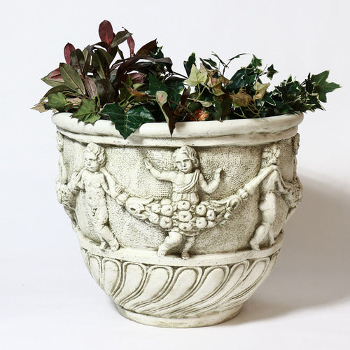 Ornate old world European planter with classical relief of dancing cherubs and garlands in a Baroque-inspired decorative style. Side Angle