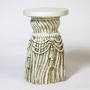 Bust of a distinguished man in classical attire atop an ornate, old world European pedestal with draped rope and tassel details. Side Angle