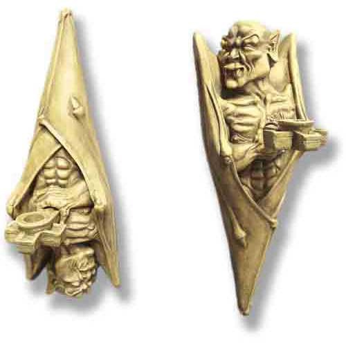Gothic gargoyle wall sconces with ornate, medieval detailing and expressive, classical faces holding candle holders.