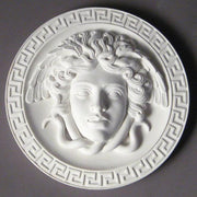 Medusa head relief with flowing serpentine hair, surrounded by a Greek key border in classical old world European style. Different Angle