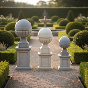Ornate old world European finials with classical rounded tops and fluted bases on square pedestals in three graduated sizes. Side Angle