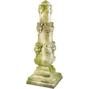 Ornate old world European pedestal with classical lion head motifs and weathered, moss-accented Baroque architectural details.