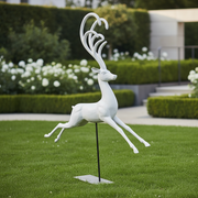 Leaping stag sculpture with elongated, ornate antlers in a classical, old world European style on a minimalist stand. Side Angle