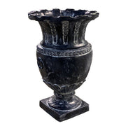 Ornate classical urn with fluted rim, laurel leaf detailing, and ring handles in an old world European style. Side Angle