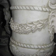 Ornate classical urn with ram head accents, laurel garland, and fluted pedestal in old world European Baroque style. Additional Angle