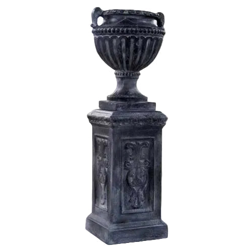 Ornate classical urn with fluted detailing and handles, set atop a square pedestal with intricate old world European reliefs.