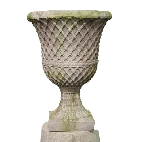 Ornate classical urn with fluted pedestal and intricate lattice pattern, featuring old world European and Renaissance design elements.