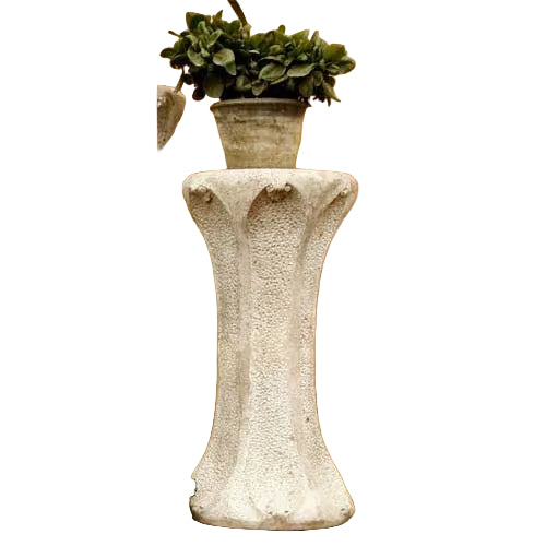 Ornate classical pedestal with fluted details and a potted plant on top, featuring old world European architectural style.