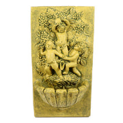 Baroque wall fountain with ornate relief of three cherubs playing among grapevines and leaves in classical old world European style Side View