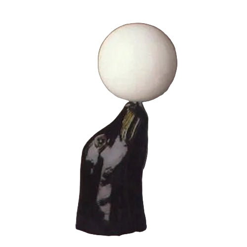 Sculpted black horse head in classical style balancing a smooth, round orb atop its nose, evoking old world European elegance.