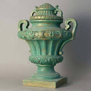 Ornate old world European urn with classical Baroque detailing, fluted body, scroll handles, and decorative lid on pedestal base Side Angle