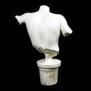 Classical Greek male torso sculpture with missing head and arms, displayed on an ornate fluted pedestal in old world European style. Different Angle