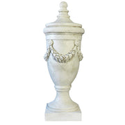Ornate classical urn with garland relief and pedestal base, featuring a detached finial lid, in old world European style. Side Angle
