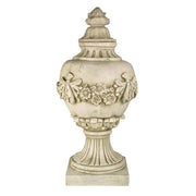Ornate classical urn with Baroque floral garland, fluted pedestal base, and old world European decorative detailing.