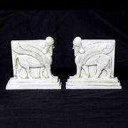 Sphinx-shaped ornate bookends with classical old world European detailing, supporting two upright hardcover books. Other Angle