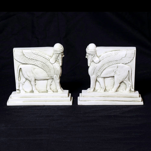 Sphinx-shaped ornate bookends with classical old world European detailing, supporting two upright hardcover books. Other Angle