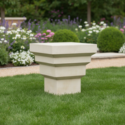 Square pedestal with stepped, geometric tiers in a classical architectural style, evoking old world European design elements. Side Angle