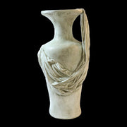 Classical Greek-style vase with an ornate draped fabric detail, evoking an old world European aesthetic. Side Angle