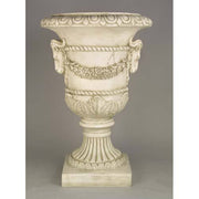 Ornate classical urn with ram head accents, laurel garland, and fluted pedestal in old world European Baroque style. Different Angle