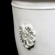 Classical urn planter with ornate Baroque shell motifs and a pedestal base, featuring old world European design elements. Side Angle