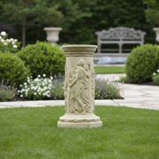 Classical Greek-style pedestal with ornate reliefs of draped figures and intricate decorative patterns in old world European design. Side Angle