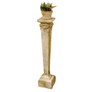 Ornate classical pedestal with decorative capital and square base, topped with a small potted plant, old world European style.