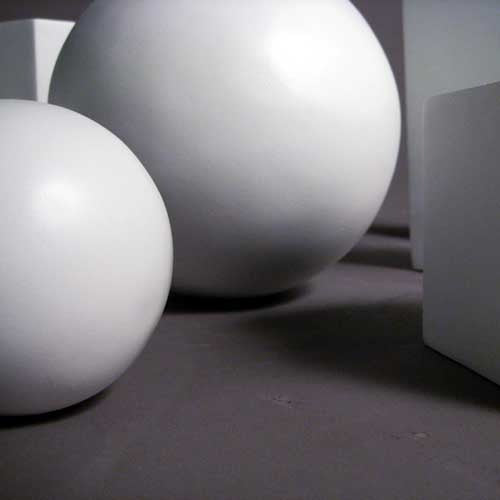 Geometric forms arranged in a group, featuring spheres, cubes, cones, pyramids, and cylinders in a classical study composition. Side Angle