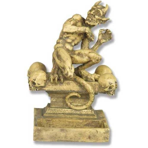 Grotesque horned demon statue in medieval Gothic style, crouching on a pedestal adorned with ornate skull details.