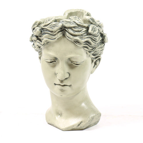 Classical Greek-style bust of a serene female figure with ornate, wavy hair and softly defined facial features. Side Angle
