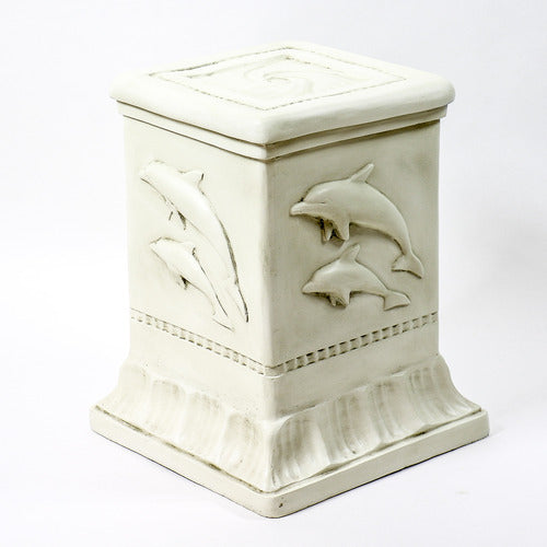 Dolphin sculpture with two dolphins leaping above ornate pedestal featuring classical reliefs in old world European style. Different Angle